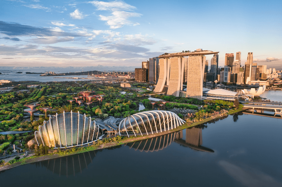 Singapore skyline with Marina Bay Sands and Gardens by the Bay at sunset.