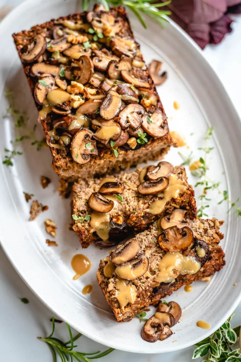 Slices of nut roast sit on a white plate.