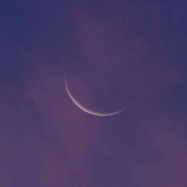 sliver moon in a purple sky