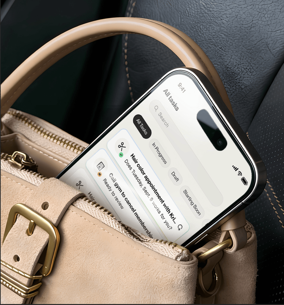 Smartphone displaying tasks list inside a beige handbag on a car seat.