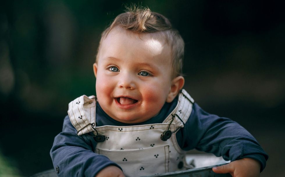 smiling baby boy in overalls