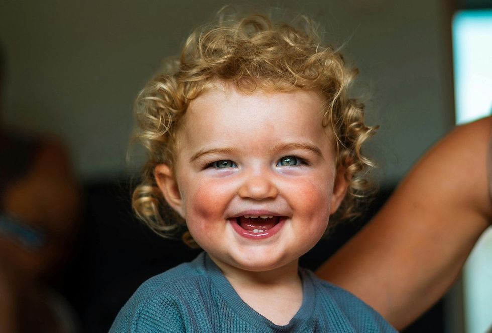 smiling baby with curly hair