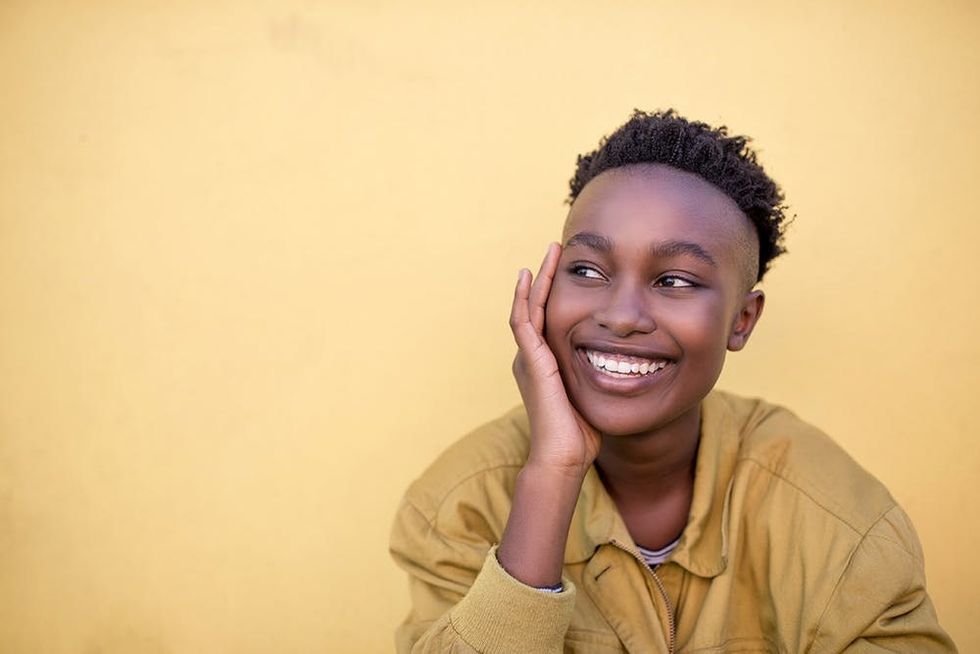 Smiling Black woman against yellow background