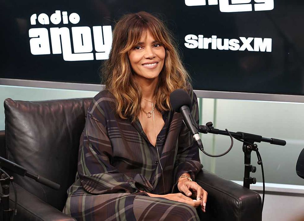 Smiling woman seated at a radio station with microphones and "SiriusXM" sign in background.