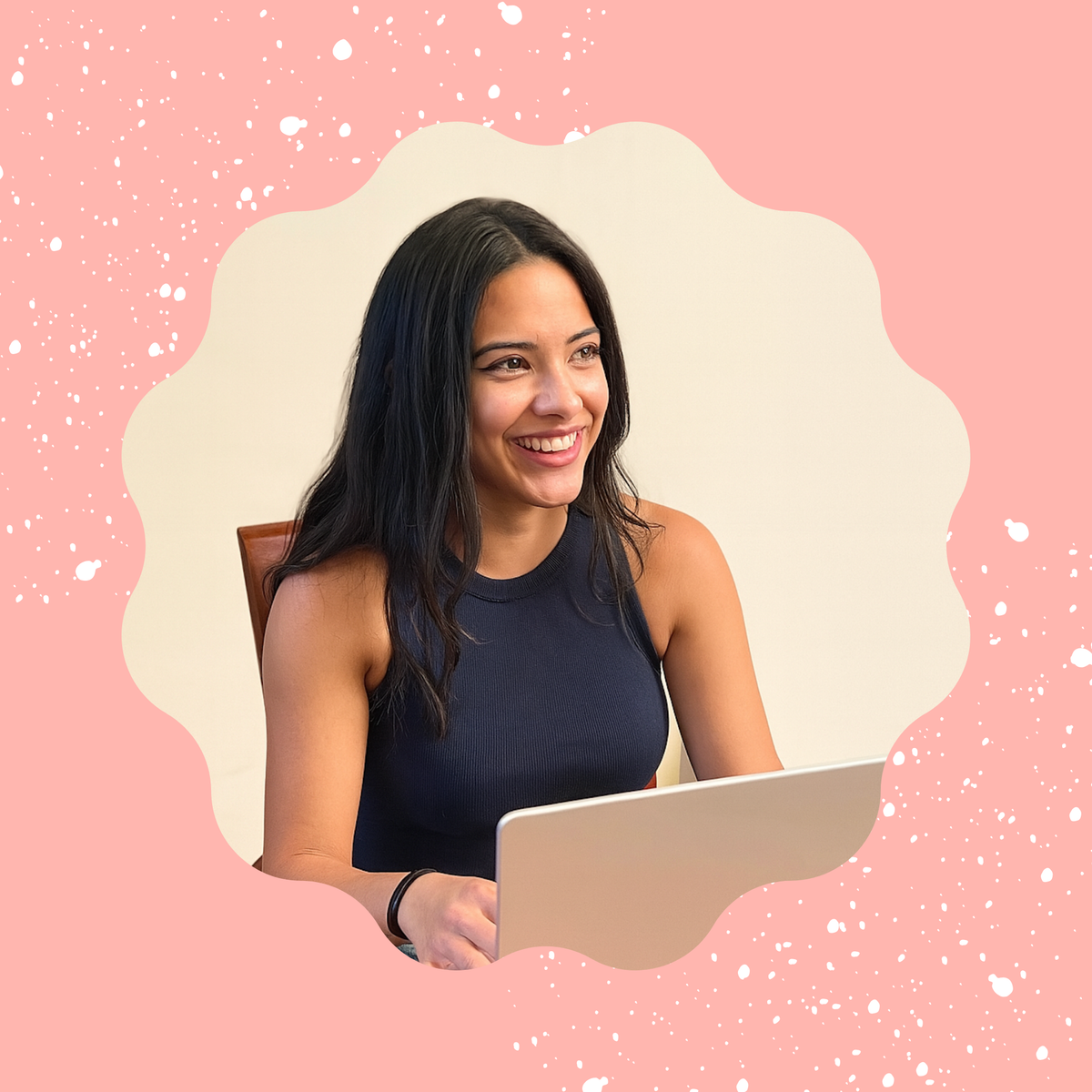 Smiling woman using a laptop against a pink, speckled background.