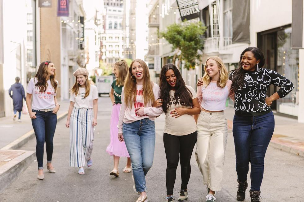 smiling women walking down the street together