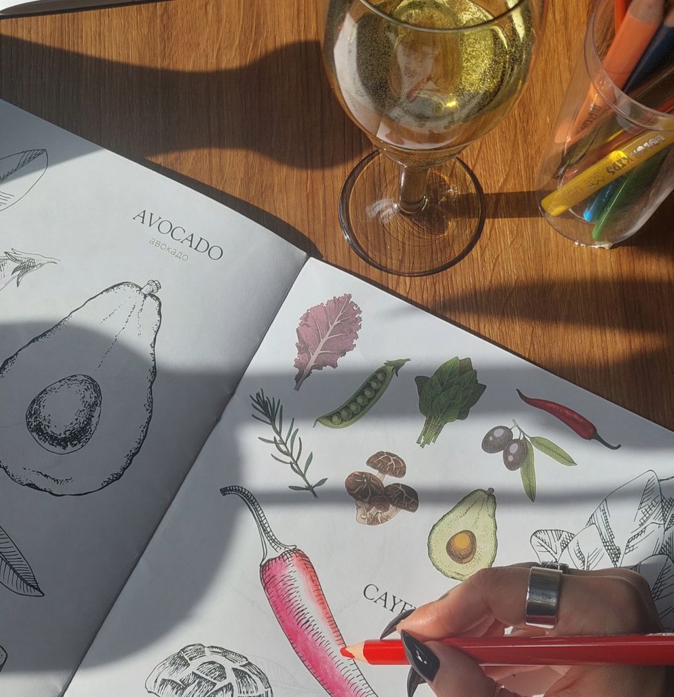 someone coloring in an adult coloring book