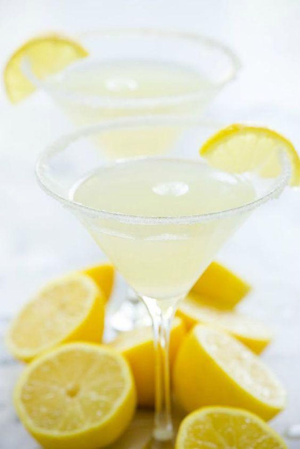 Sparkling Lemon Drop Martinis in a martini glass surrounded by lemons