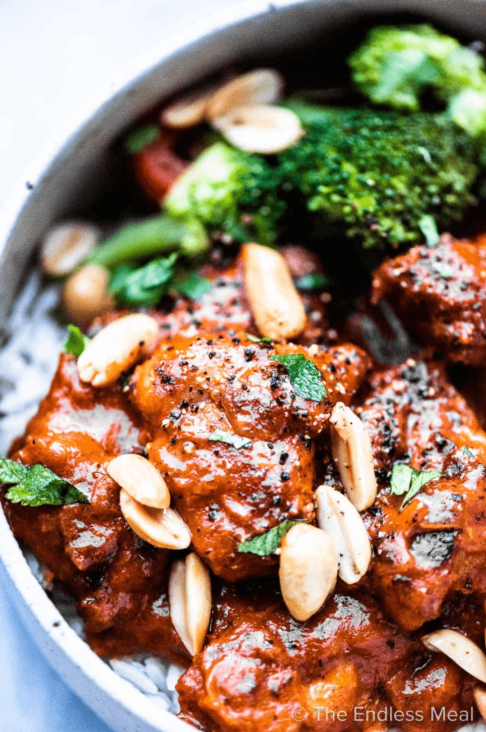 Spicy peanut chicken with broccoli and almonds on a bed of rice.