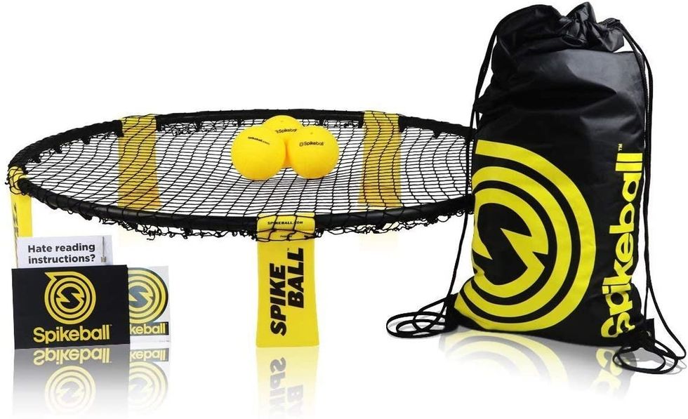 Spikeball set with net, two balls, instructions, and a drawstring bag.
