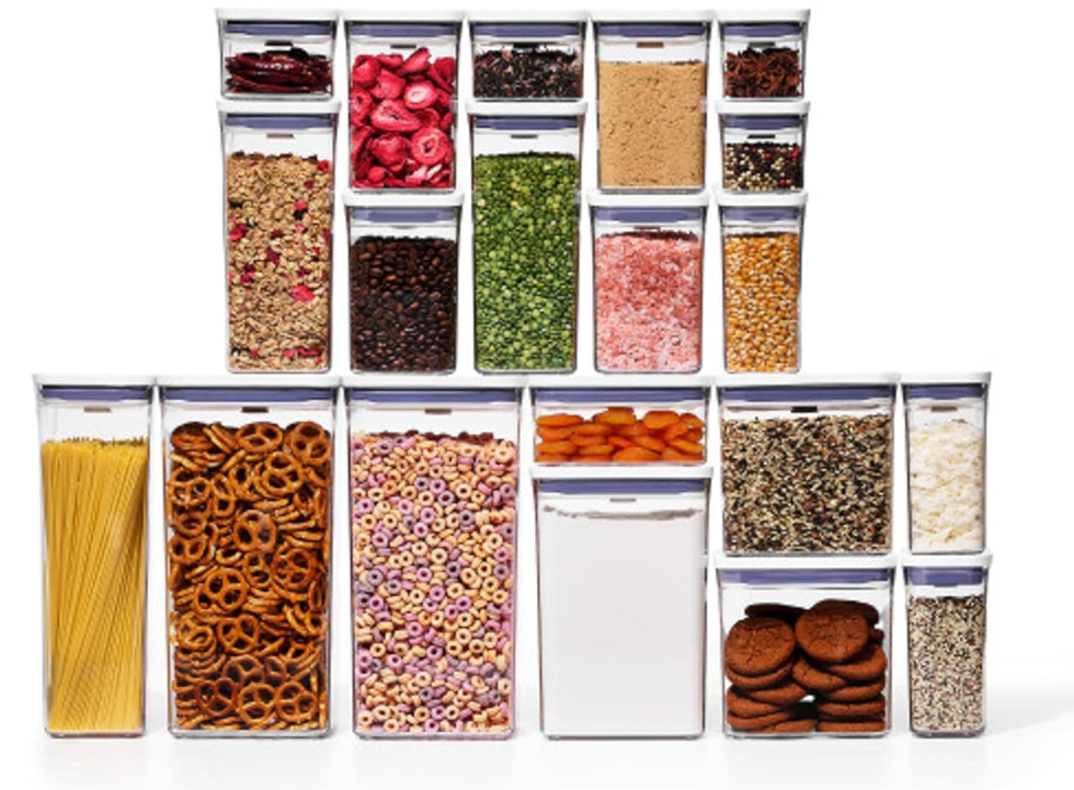 Stacked airtight containers filled with various dry foods and snacks.