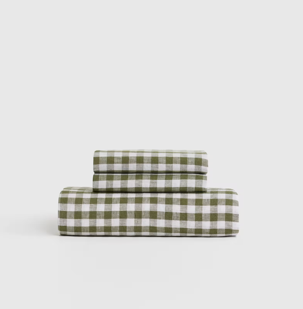 Stacked green and white checkered bedsheets on a plain background.