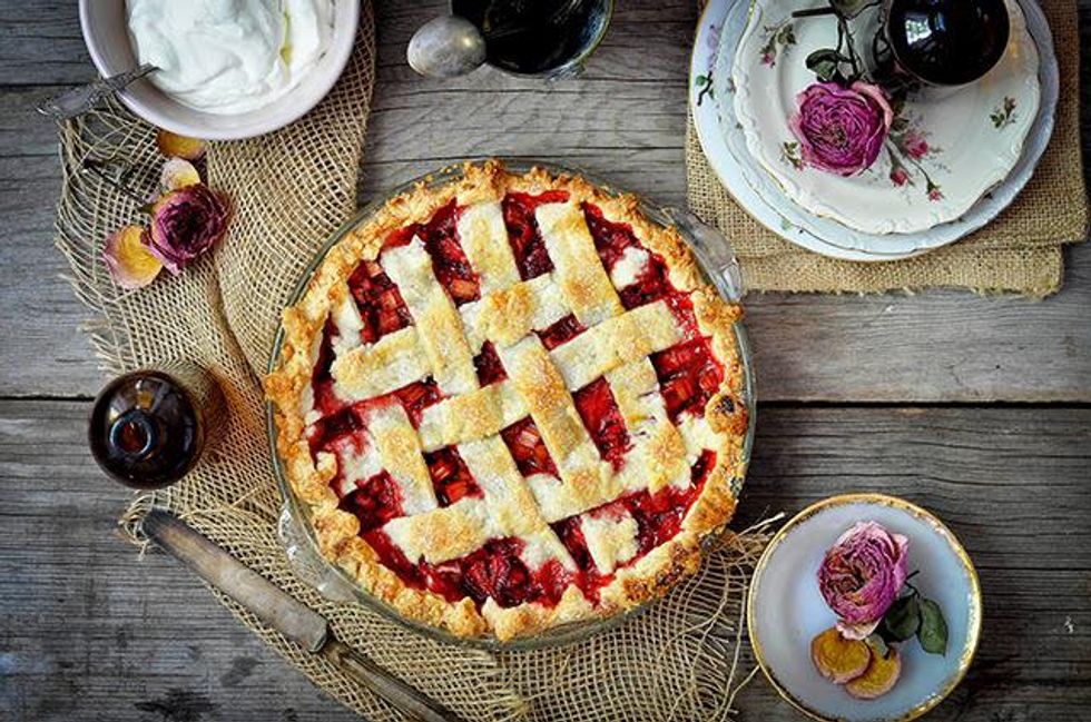 strawberry rhubarb pie with a lattice top and rose whipped cream