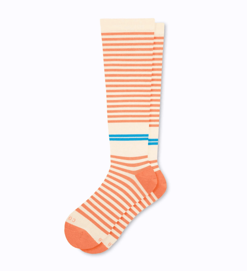Striped orange and cream socks with blue accents, laid flat.
