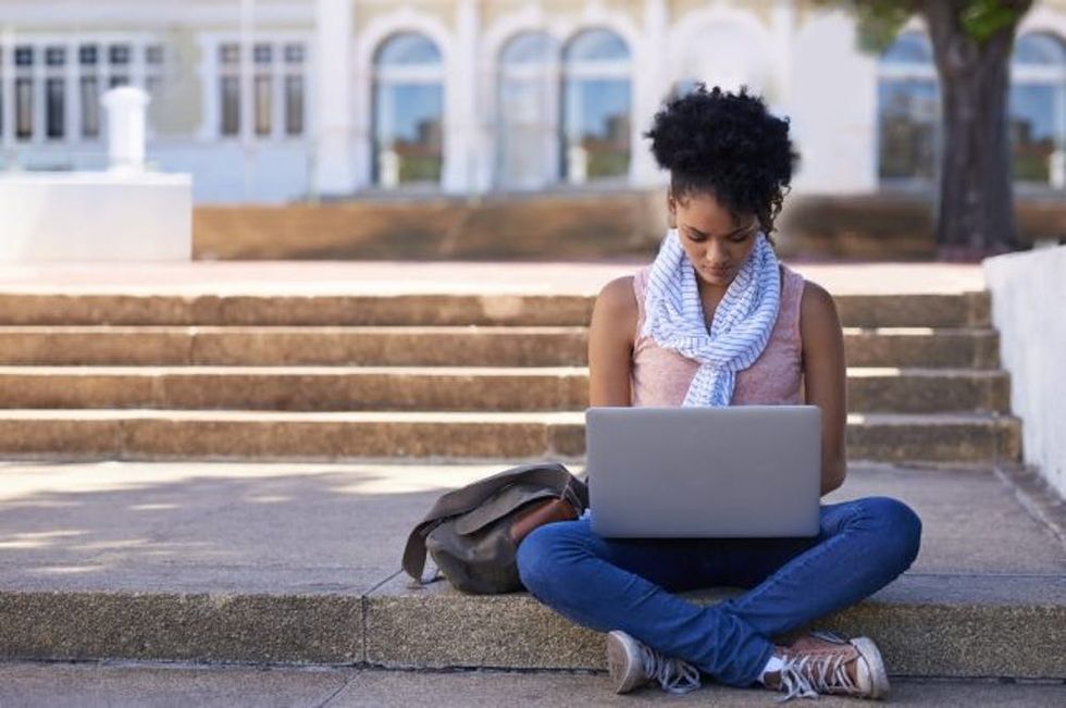 student on campus with laptop