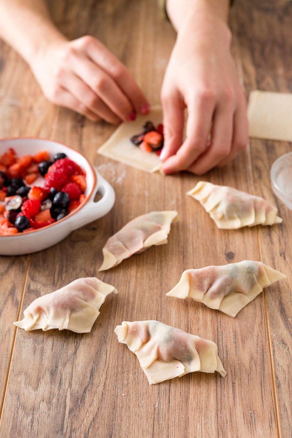 stuffing the fruit into the wrapper and sealing