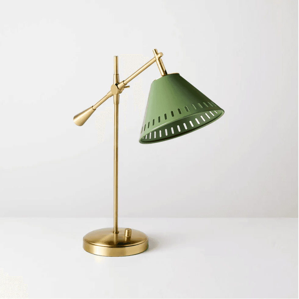 Stylish brass desk lamp with green perforated shade on a white background.
