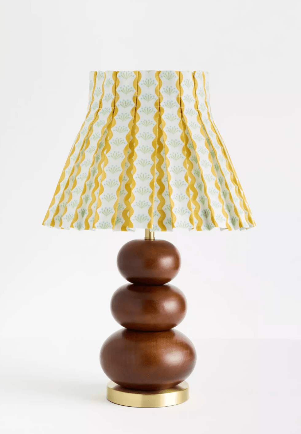 Stylish lamp with patterned shade, wooden base, and gold accents on a white background.