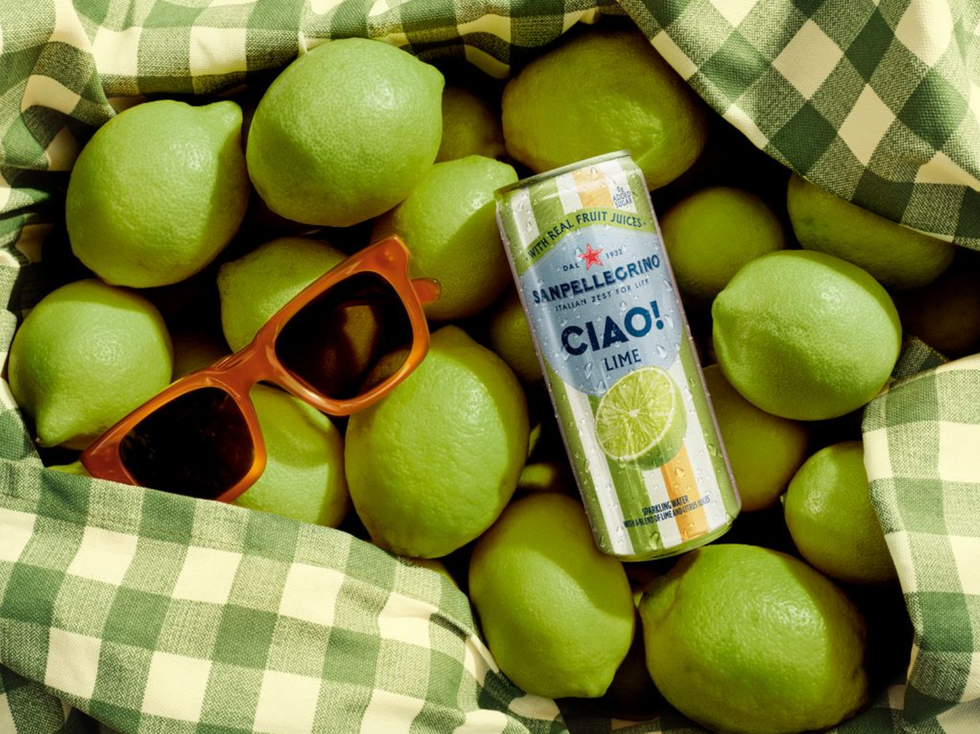 Sunglasses, lime can, and fresh limes in a checked green and white cloth.