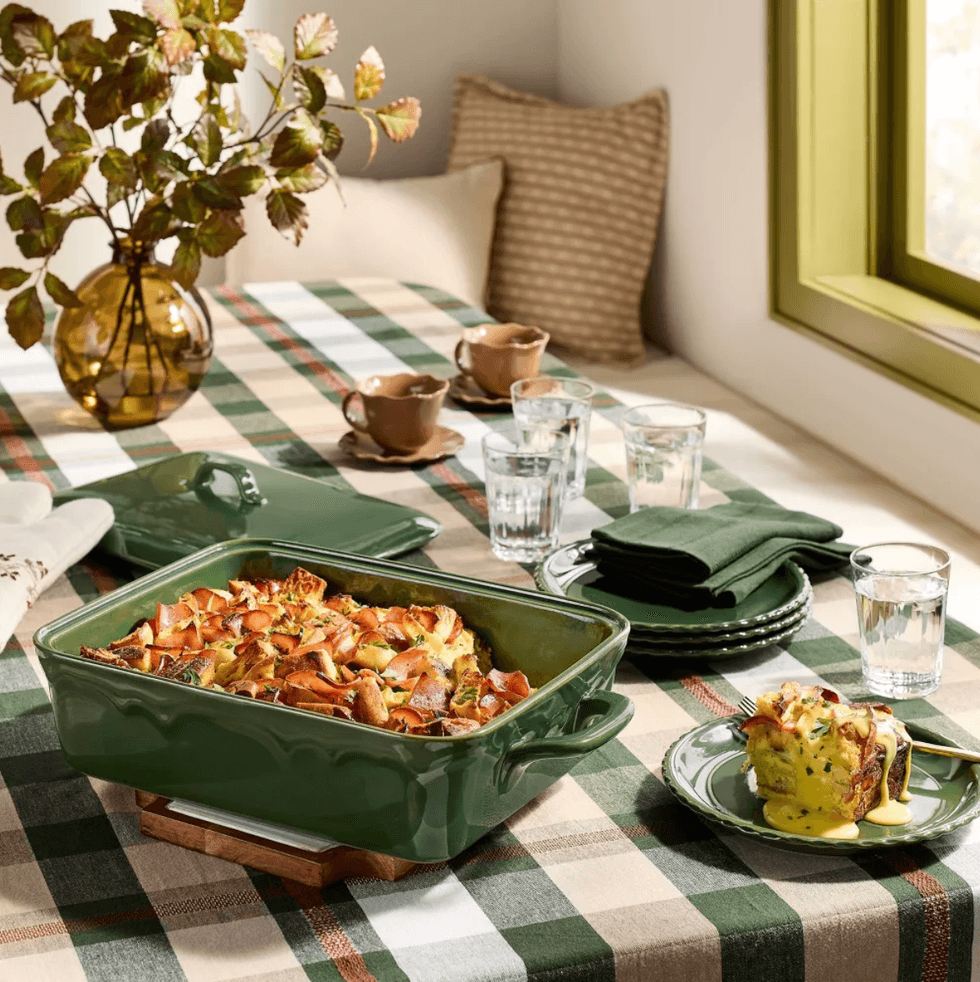 Table with casserole dish, plaid tablecloth, and autumn decor.