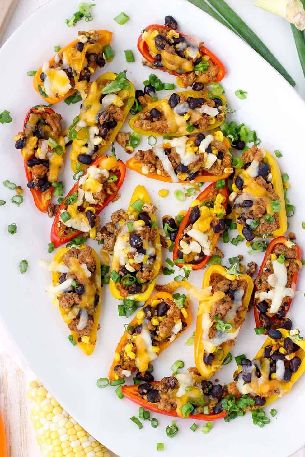 Taco stuffed mini peppers are on a white plate.