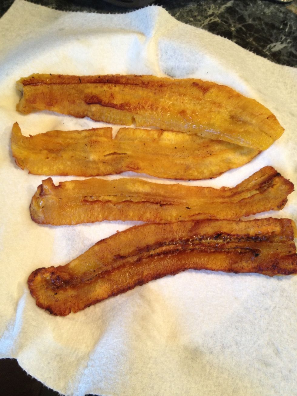 Take a plate and put a piece of paper on it and lay the now cooked plantain slices. This absorbs excess oil.