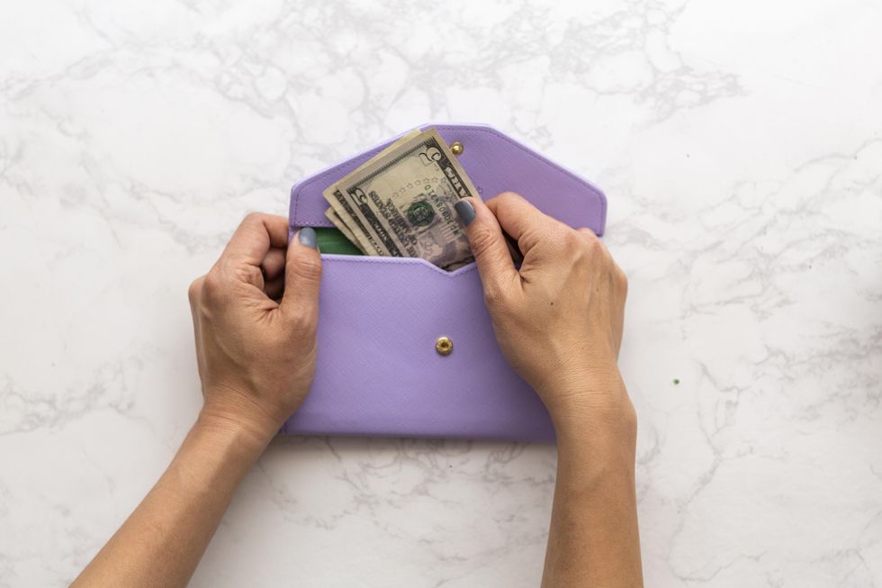 taking money out of a purple wallet