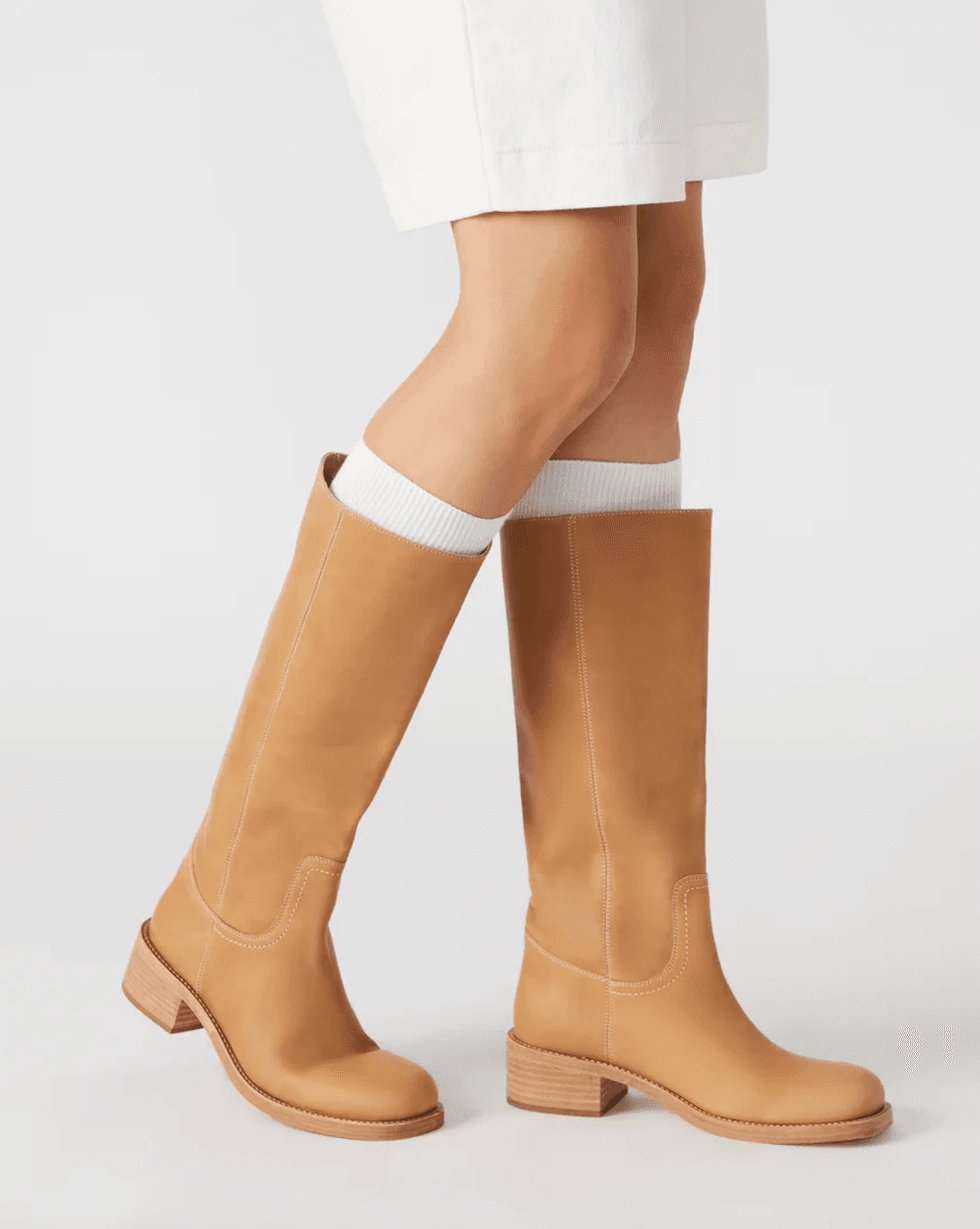Tan knee-high boots with wooden heels, worn with white knee-high socks.