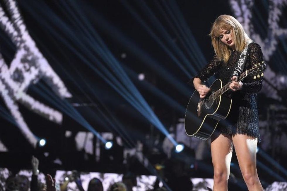 Taylor Swift on stage with guitar