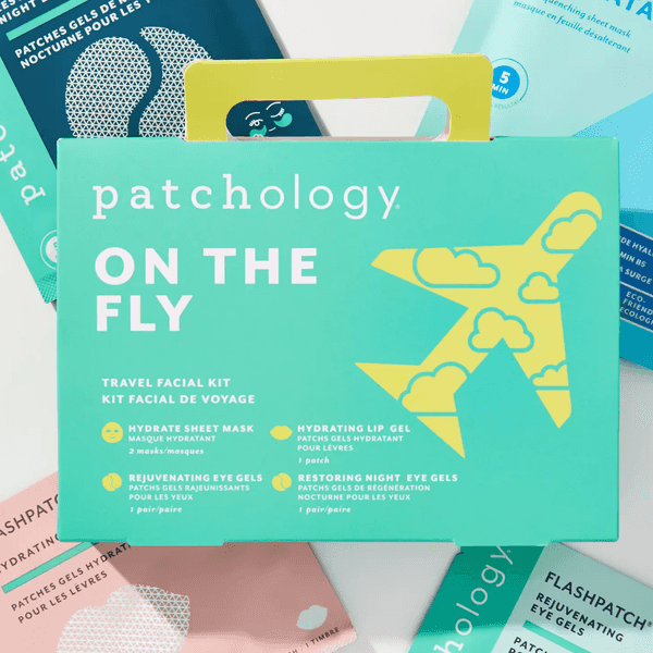 Teal travel facial kit with airplane graphic, surrounded by various colorful skincare packages.