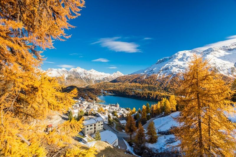 The alpine village of St. Moritz framed by colorful woods