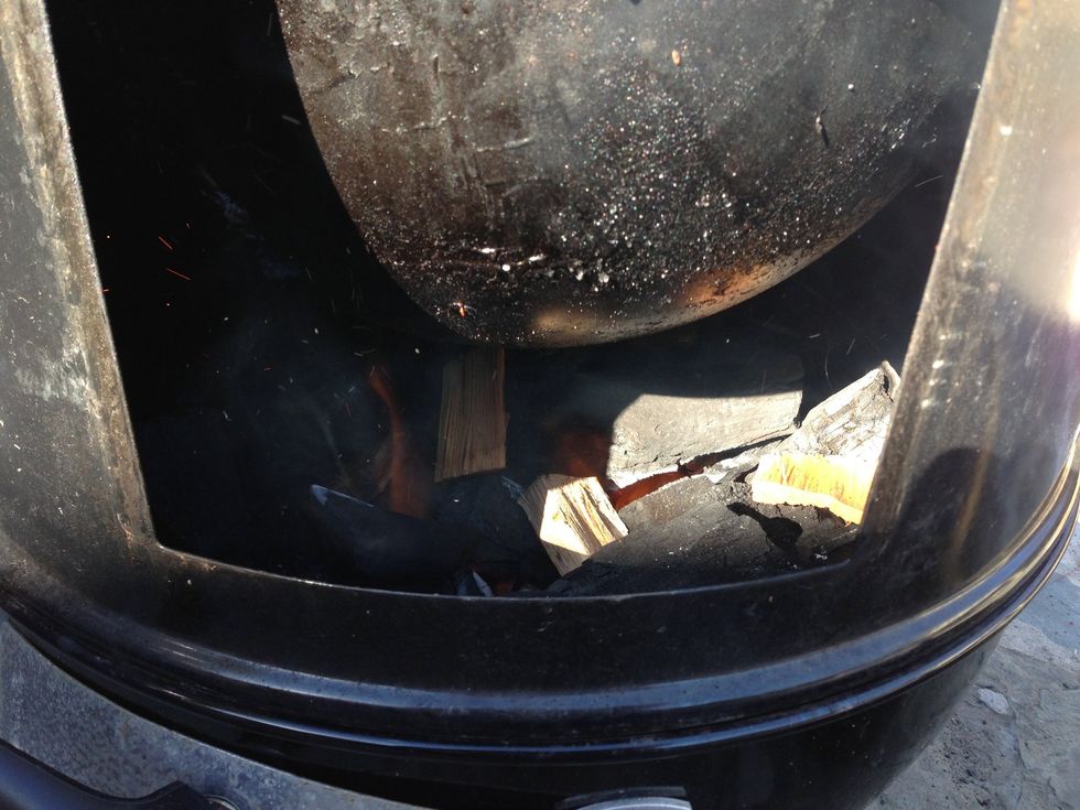 The bowl in the top of this picture is the water pan, which helps evenly distribute the heat and add some moisture to it. The soaked chips are just starting to smoke.