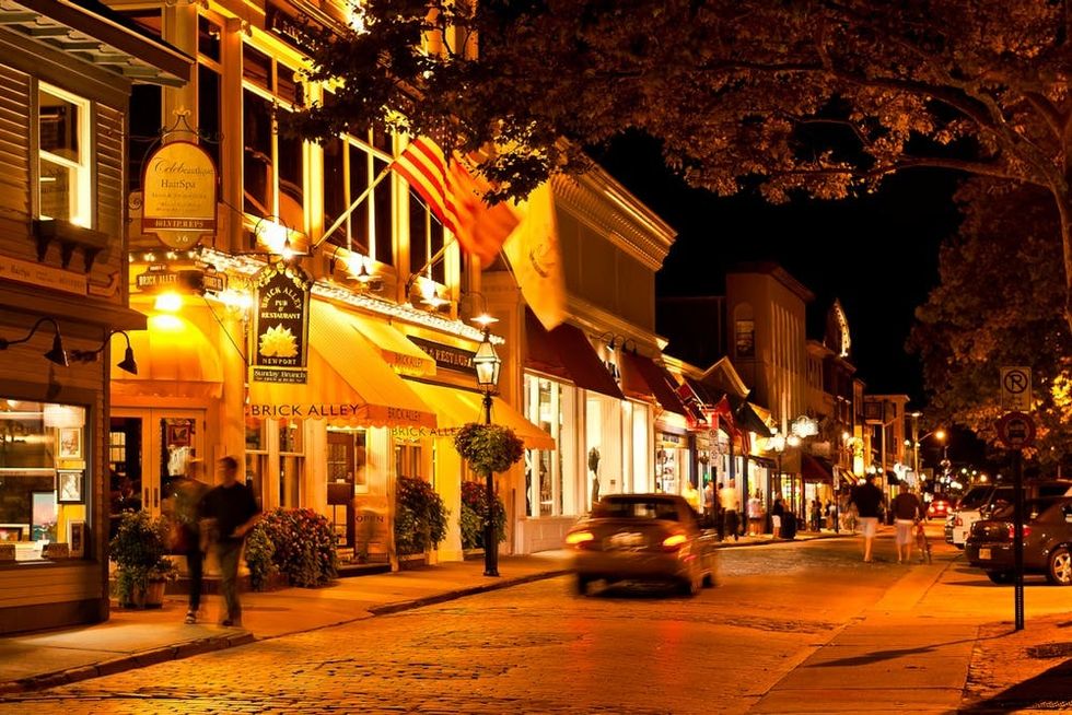 The Brick Alley restaurant and Thames Street shops glow at night