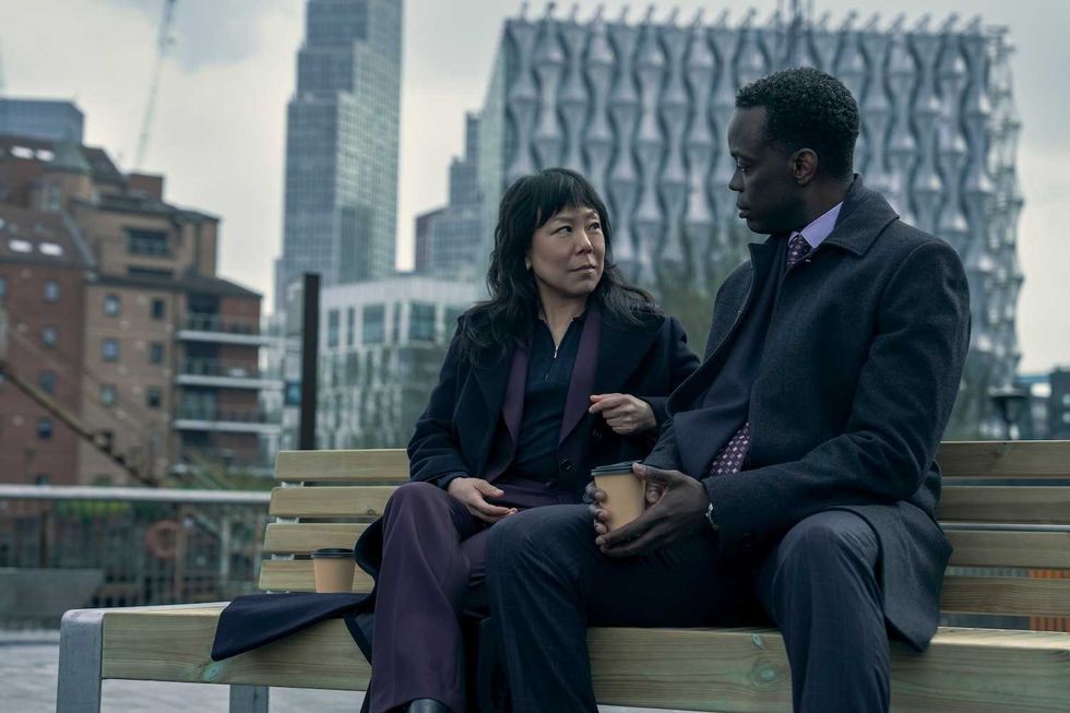 the diplomat a man and woman sitting on a bench on a gray dreary day