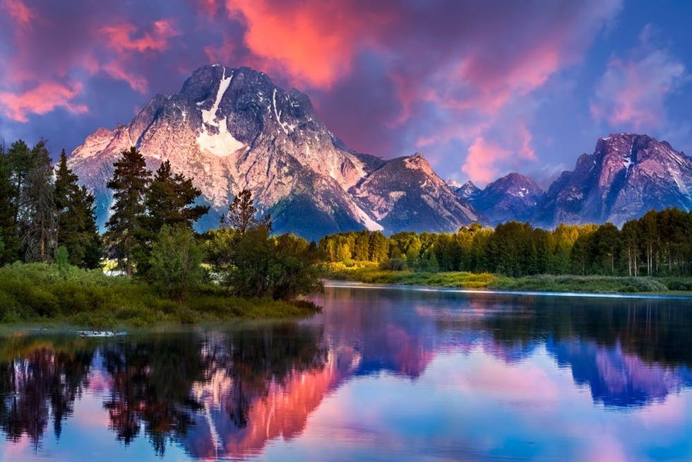 The rising sun lights up the sky over Wyoming's Snake River