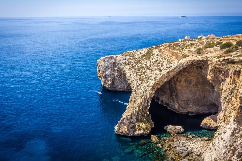 The sun shines on the waters around the Blue Grotto