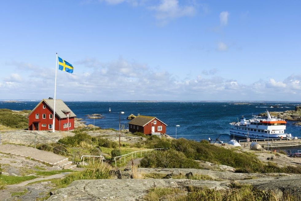 The Swedish flag flies over a rocky coast in Gothenburg