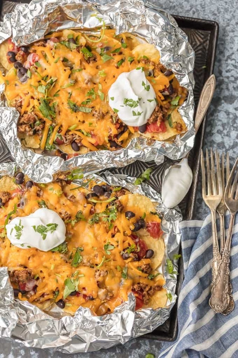 These foil pack nachos with black beans, cheese, cilantro, and sour cream are another easy camping foods