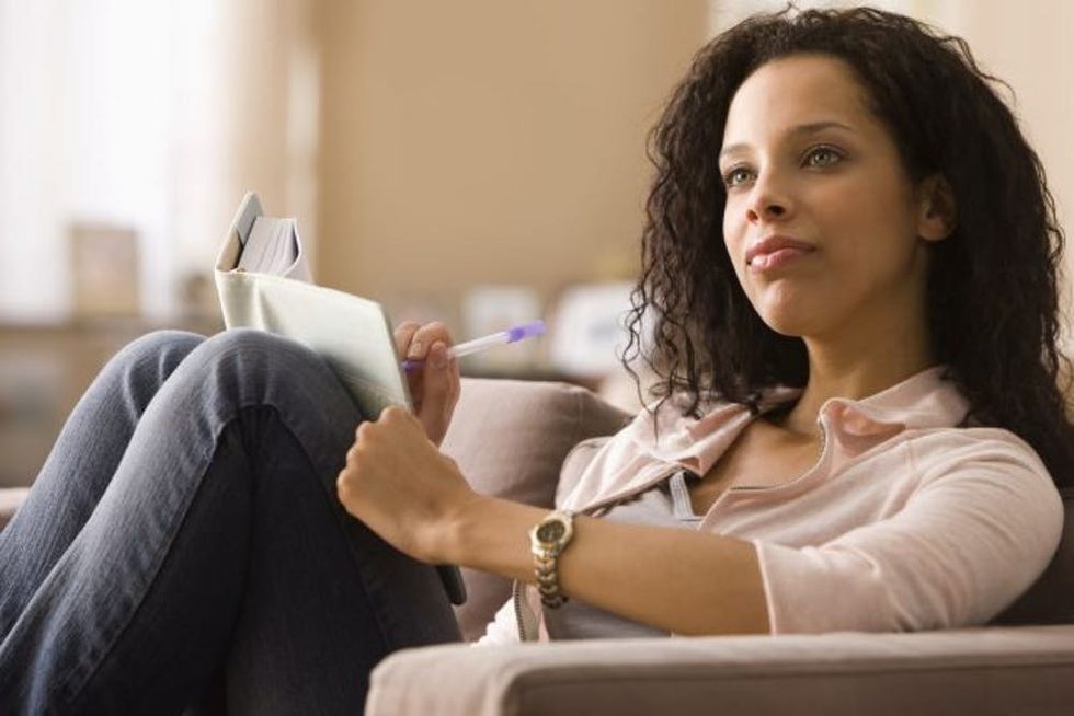 Thoughtful woman writing in journal