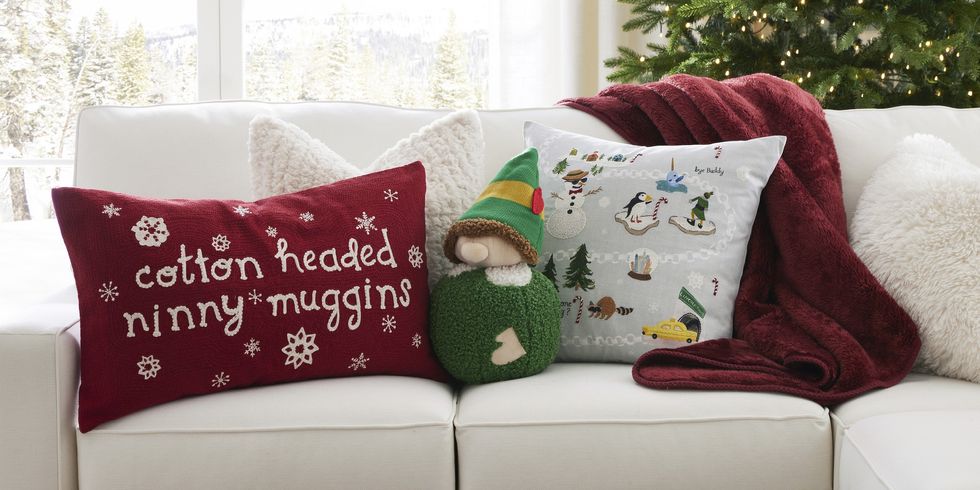 Three Elf-themed pillows sit on a white couch.