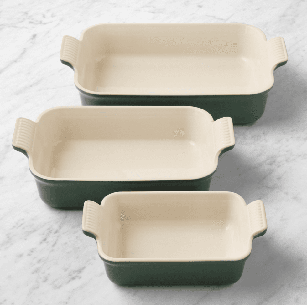 Three green and cream rectangular baking dishes on a marble surface.