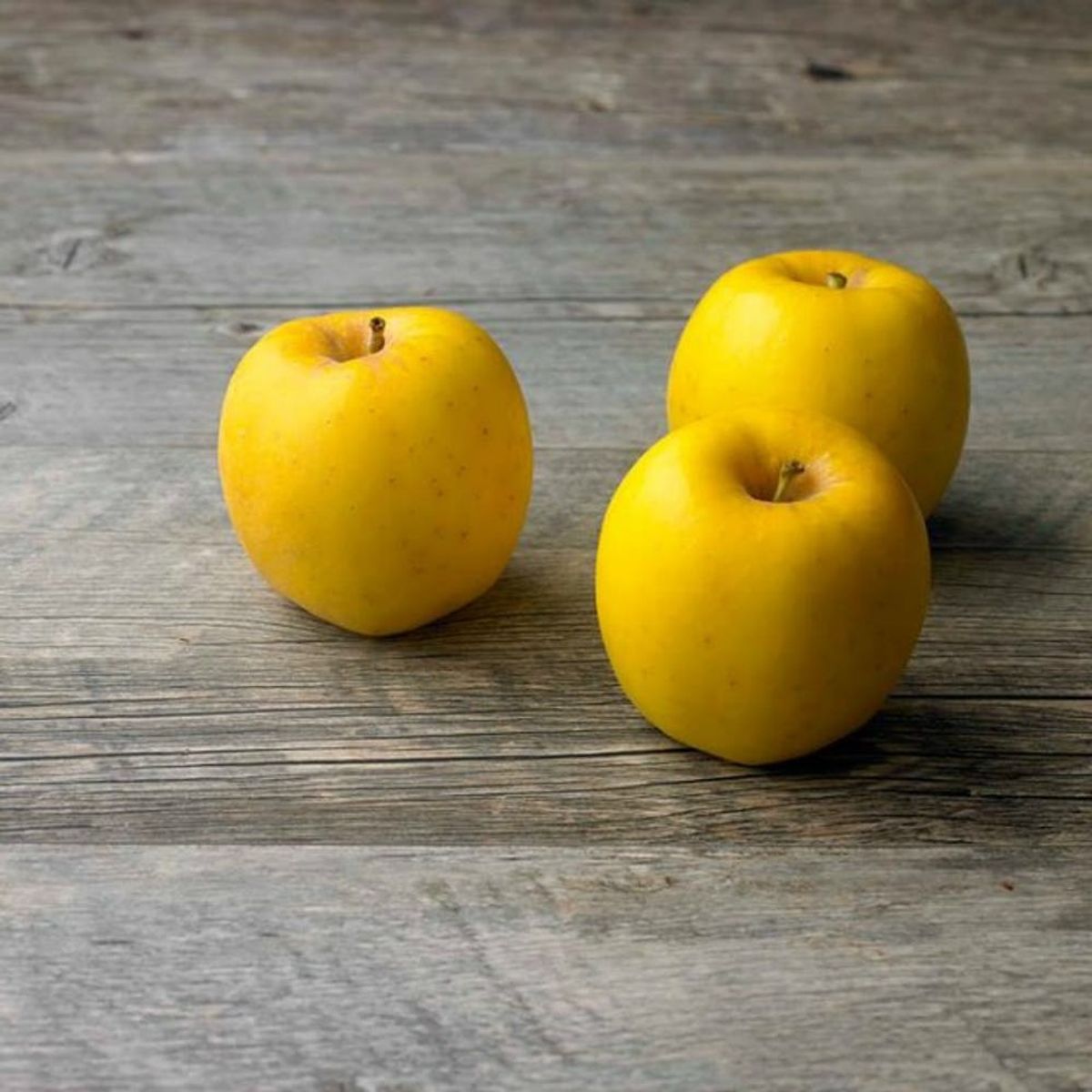 Three Opal Apples on a brown table