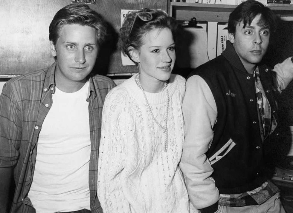 Three people posing together in a candid black-and-white shot.