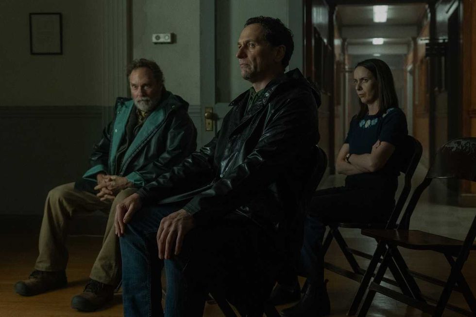 three people sitting in a dimly lit room