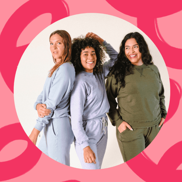 Three people smiling in casual outfits against a pink, abstract background.