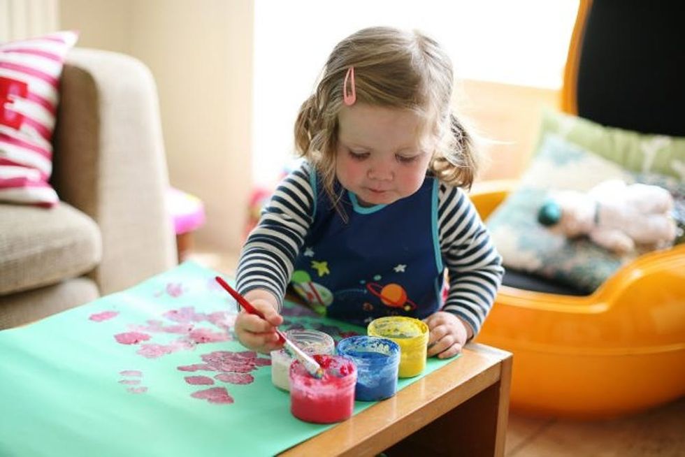 Toddler girl painting at home