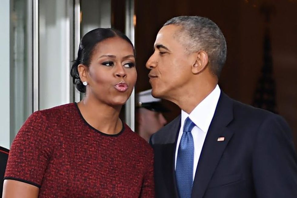 TOPSHOT - US President Barack Obama and First Lady Michelle Obama kiss as they prepare to greet President-elect Donald Trump and his wife Melania to the White House in Washington, DC January 20, 2017. / AFP / JIM WATSON (Photo credit should read JIM WATSON/AFP/Getty Images)