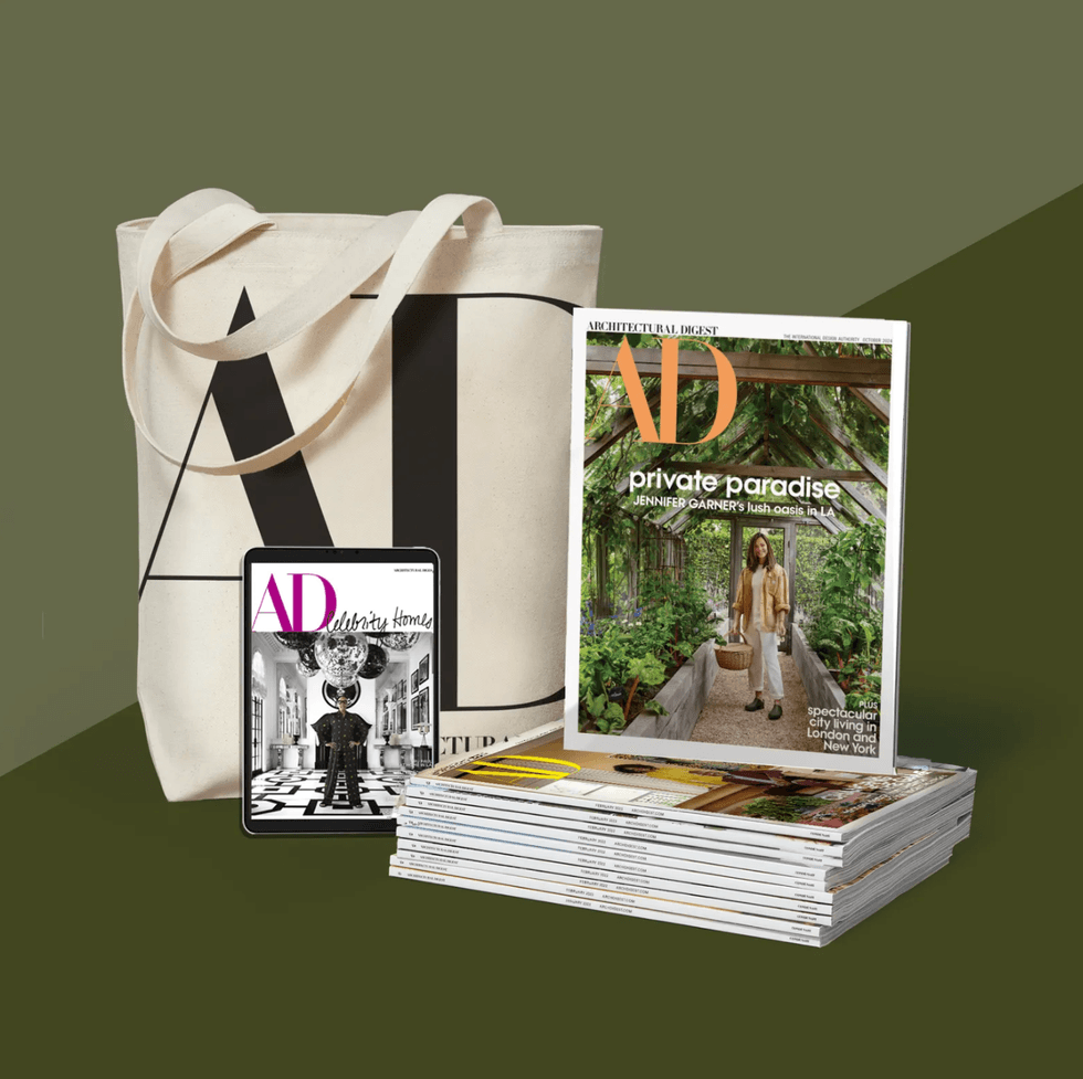 Tote bag, tablet, and Architectural Digest magazine stack on an olive background.