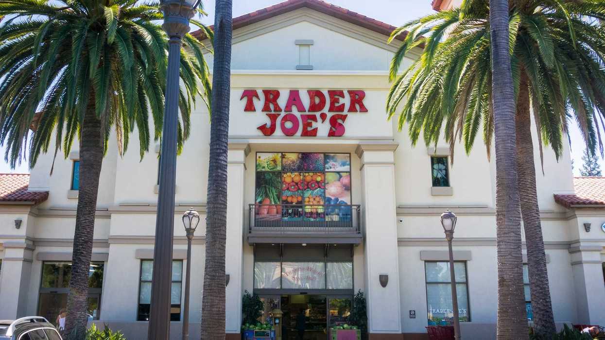 Trader Joe's entrance with palm trees and colorful fruit display.
