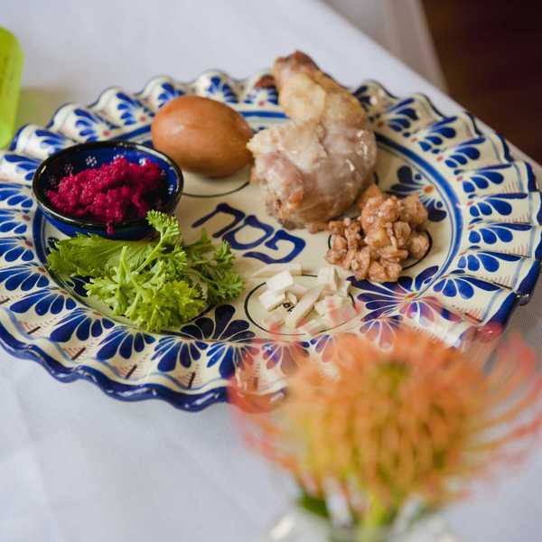 Traditional Seder plate with symbolic foods for Passover on a decorated plate.